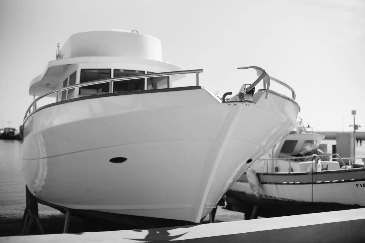 White motor yacht with an anchor on the bow in a harbor