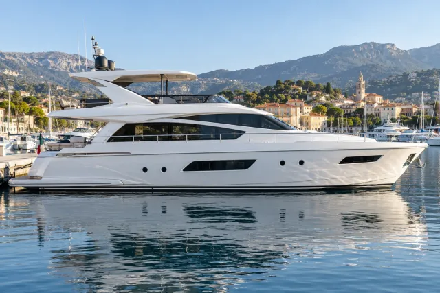A modern 60-foot motor yacht shown in side profile at a Mediterranean marina