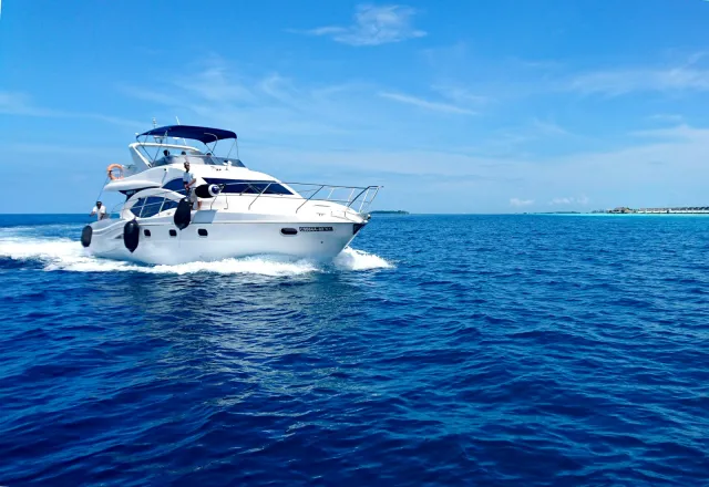 White motor yacht cruising on blue sea under a clear sky