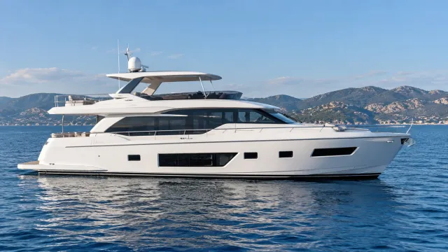 Side profile of an illustrative 80-foot-class white motor yacht on calm coastal water