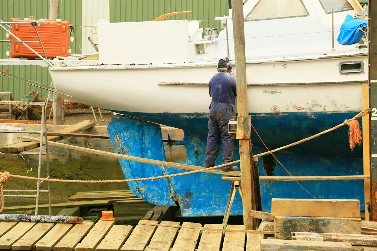 Technician working on a yacht in dry dock during hull maintenance