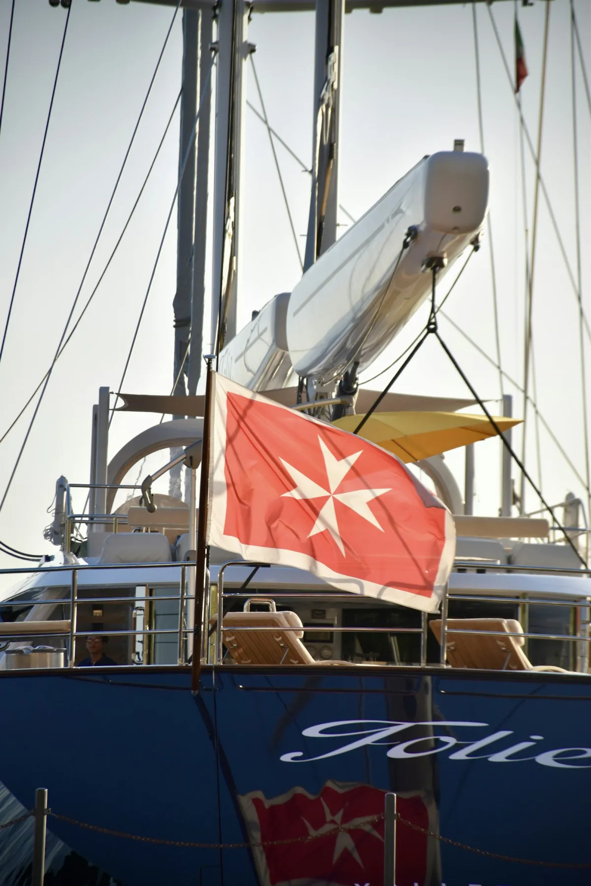 Red Maltese cross flag flying from a yacht